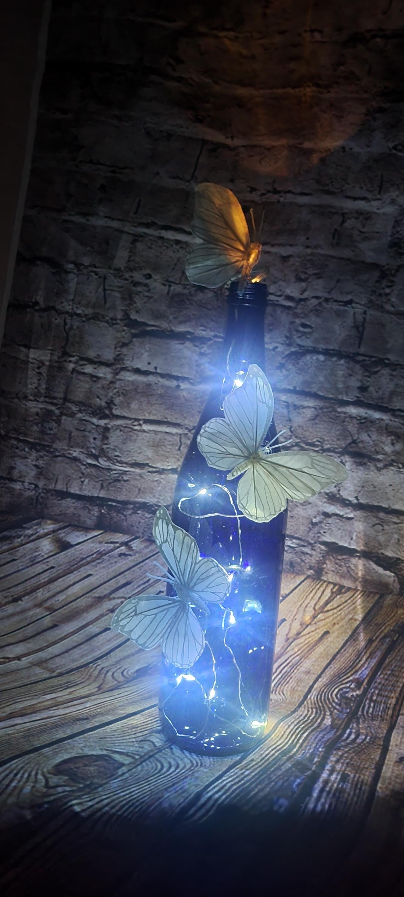 Cobalt blue wine bottle electric LED lights with white butterflies table decor centerpiece