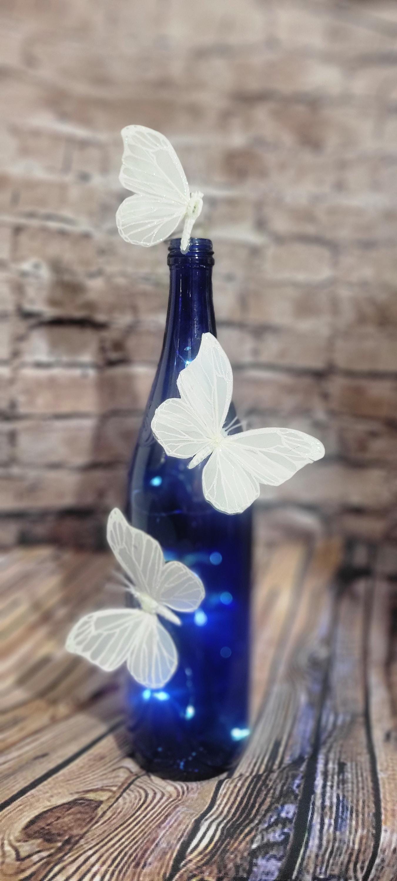 Cobalt blue wine bottle electric LED lights with white butterflies table decor centerpiece