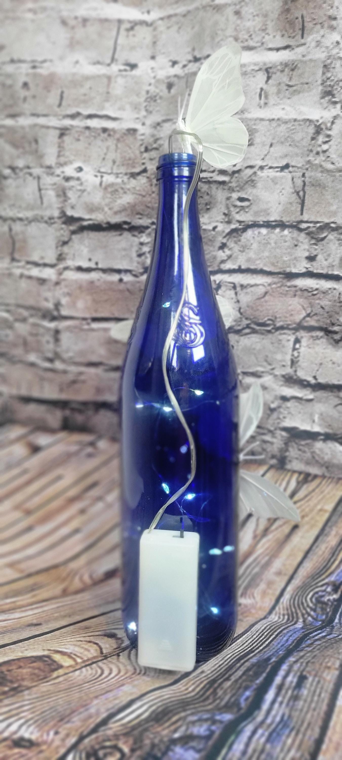 Cobalt blue wine bottle electric LED lights with white butterflies table decor centerpiece