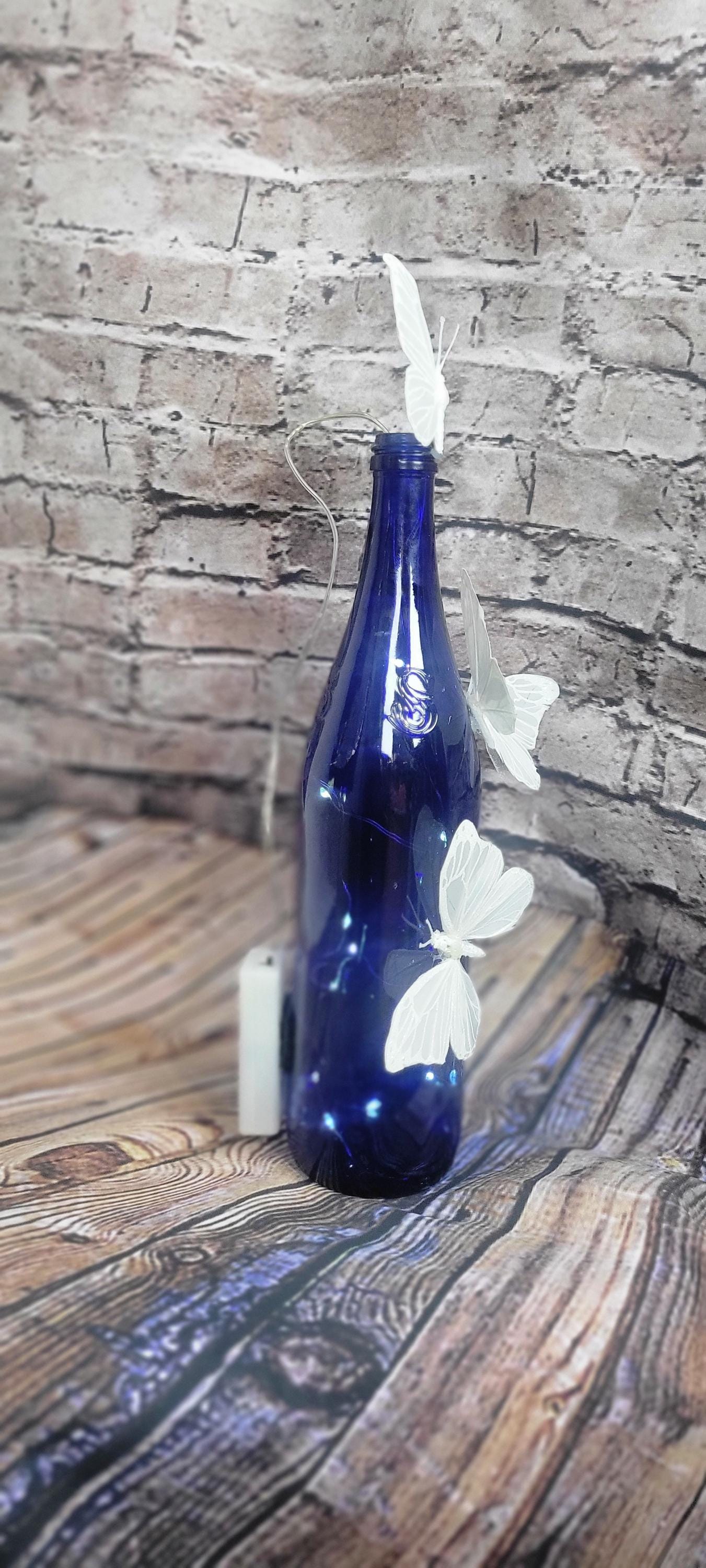 Cobalt blue wine bottle electric LED lights with white butterflies table decor centerpiece